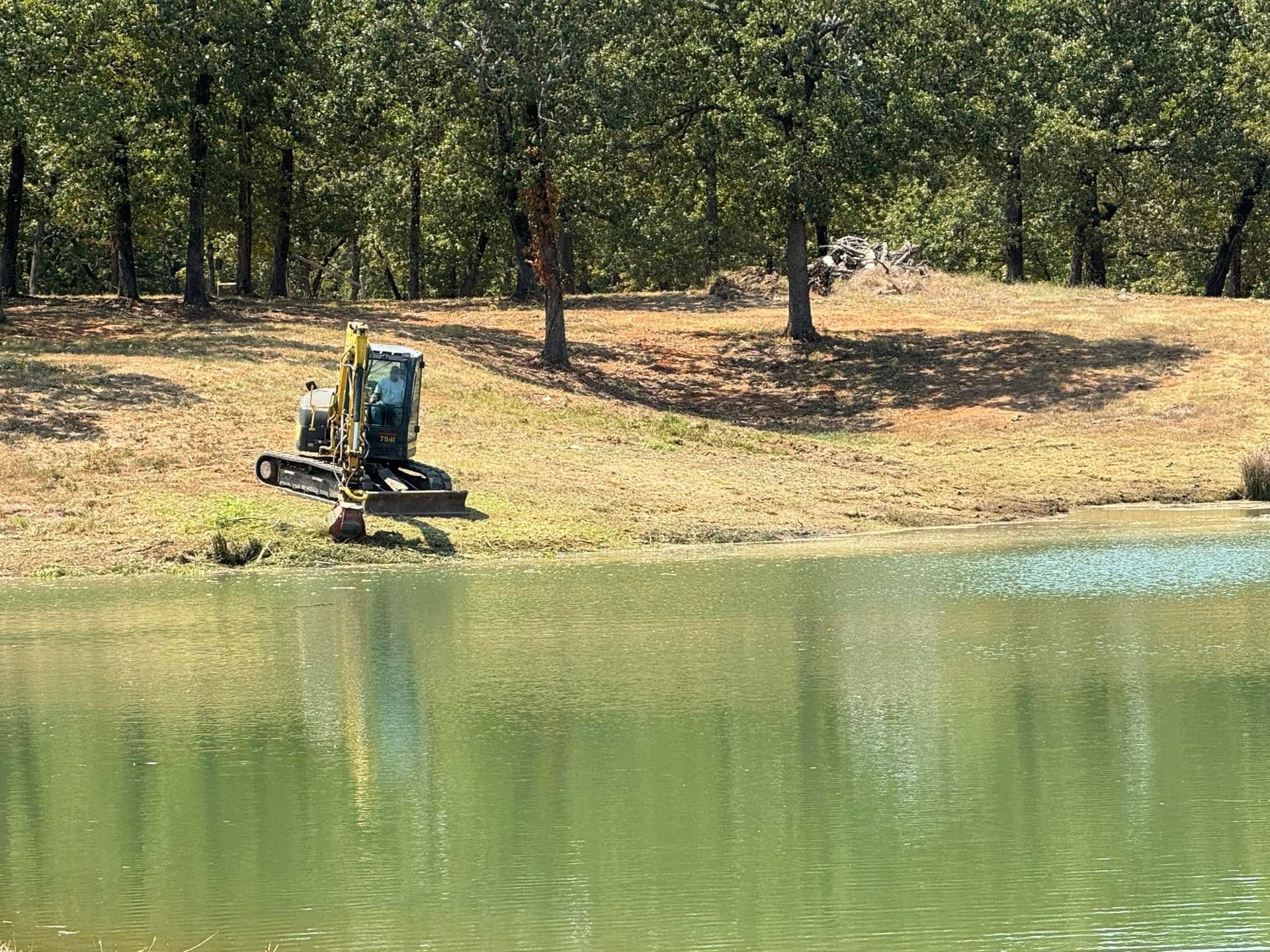 Heavy machinery in a grassy field; several pieces, some tracked, some with large tires.