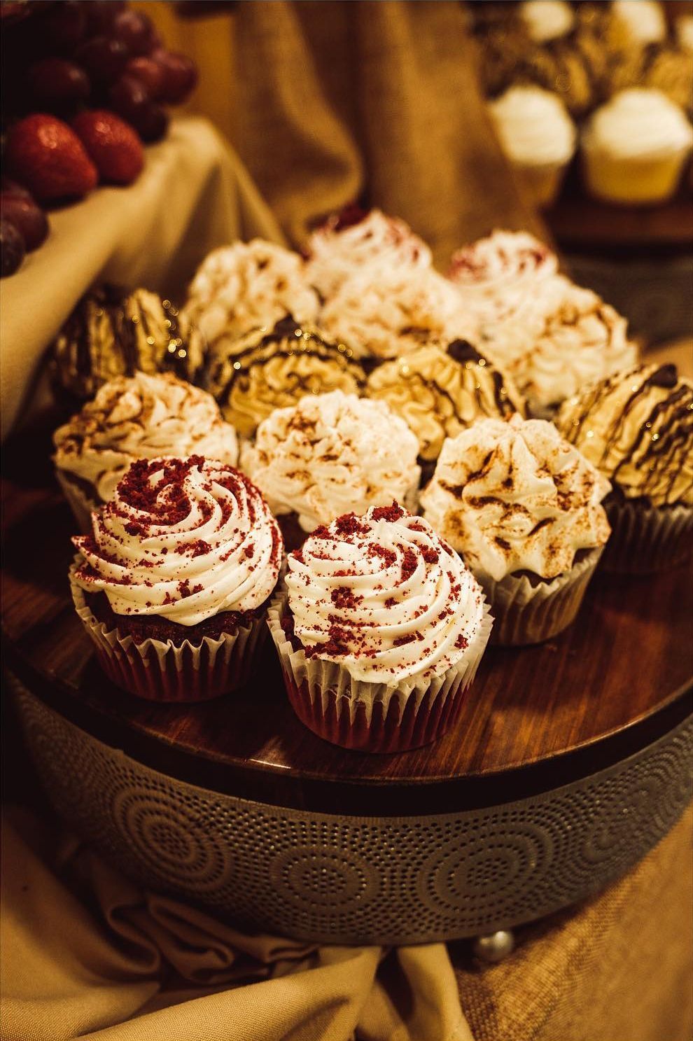 A bunch of cupcakes are sitting on top of a wooden table