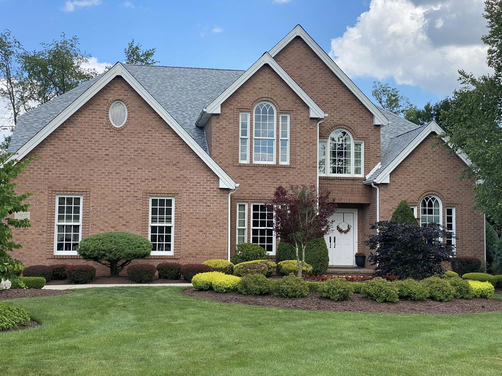 A large brick house with a blue roof and white trim