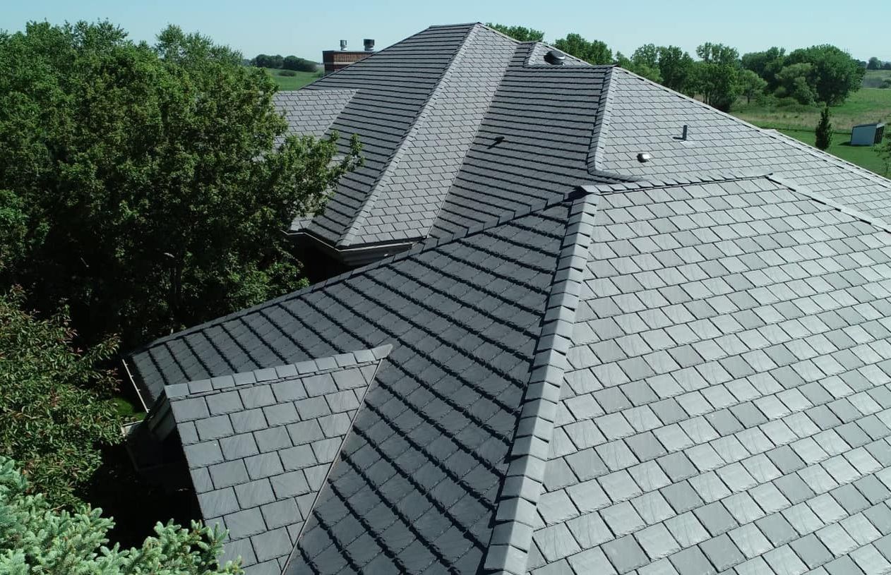 An aerial view of a house 's roof with trees in the background