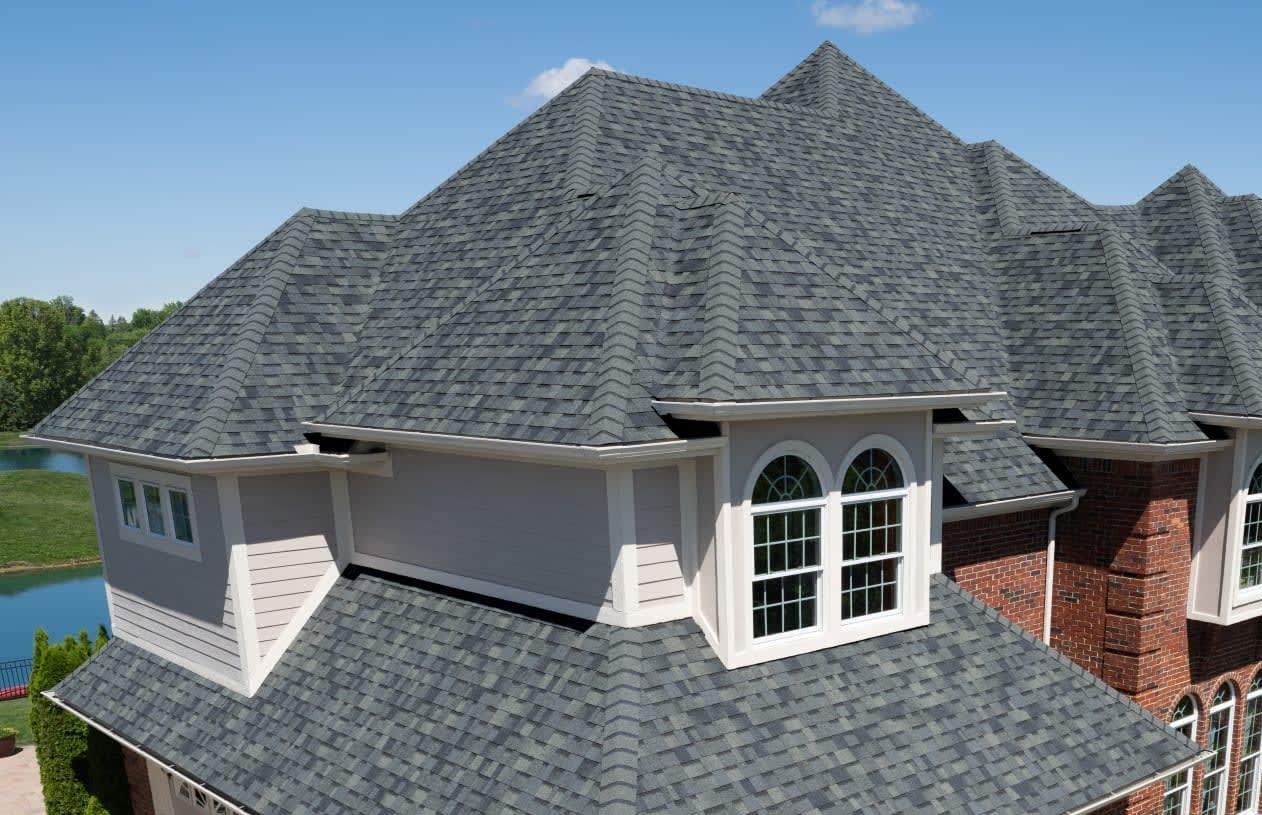 An aerial view of a large house with a gray roof.