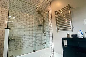 A bathroom with a bathtub, shower, and towel rack