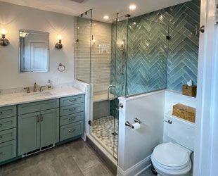 a bathroom with a shower, sink, toilet,  and mirror
