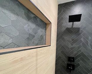 a bathroom with a shower head and a niche in the wall