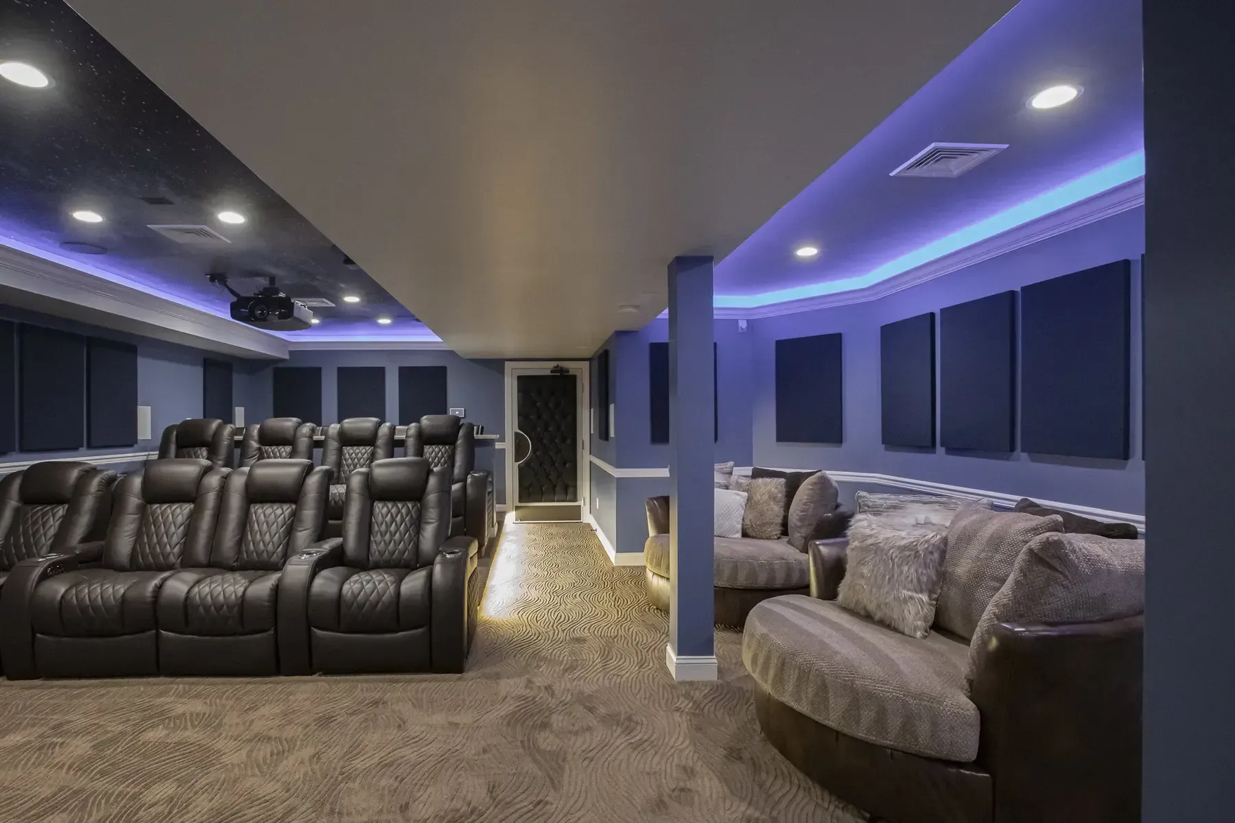 A home theater with a lot of seats and purple lights
