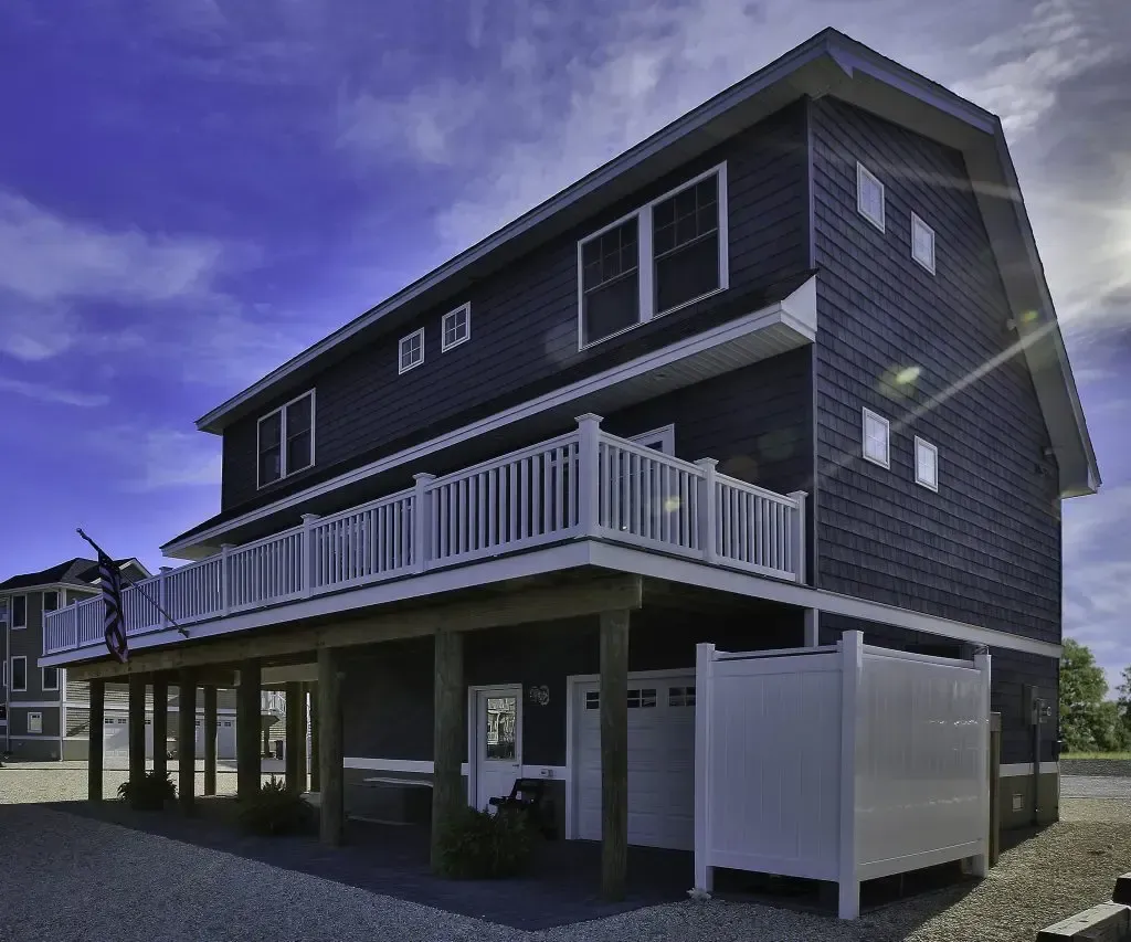 A large house with a large balcony and a white fence