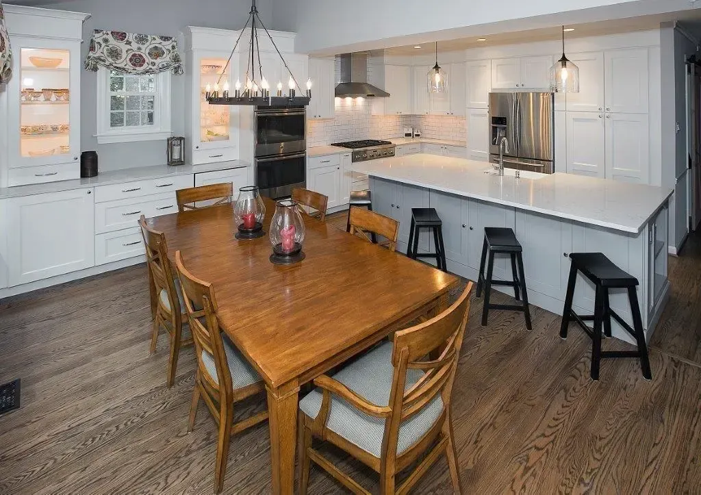 A kitchen with a large wooden table and chairs
