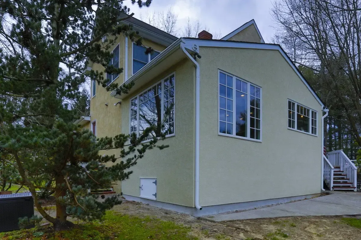 A house with a lot of windows and a tree in front of it