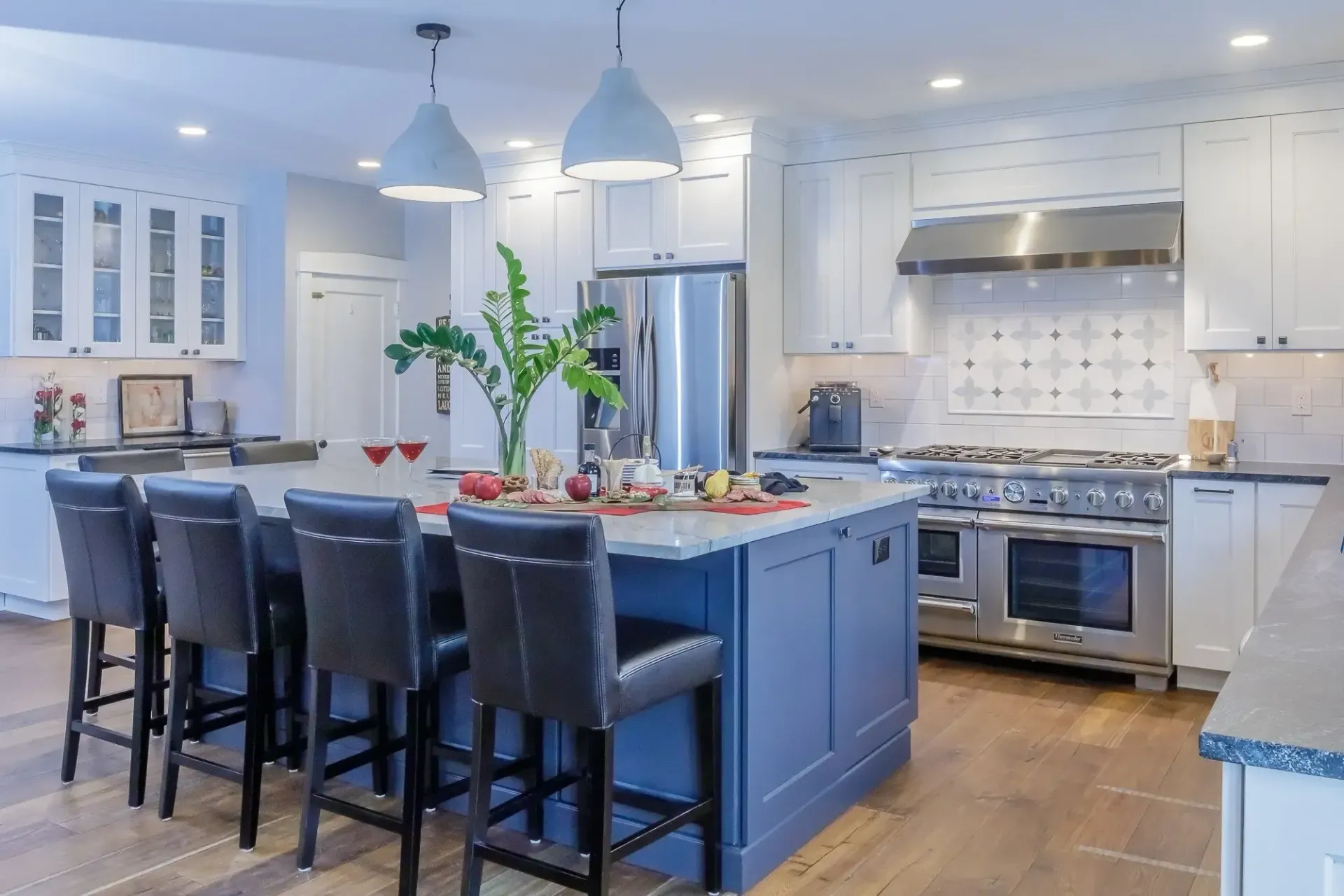 A kitchen with a large blue island and stools