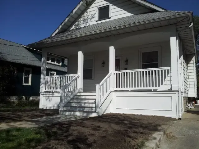 A white house with a porch and stairs