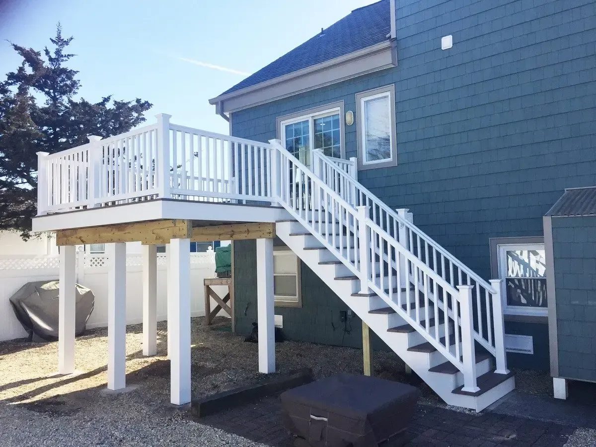 A blue house with a white deck and stairs