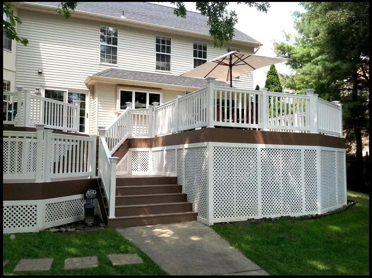 A white house with a large deck and stairs