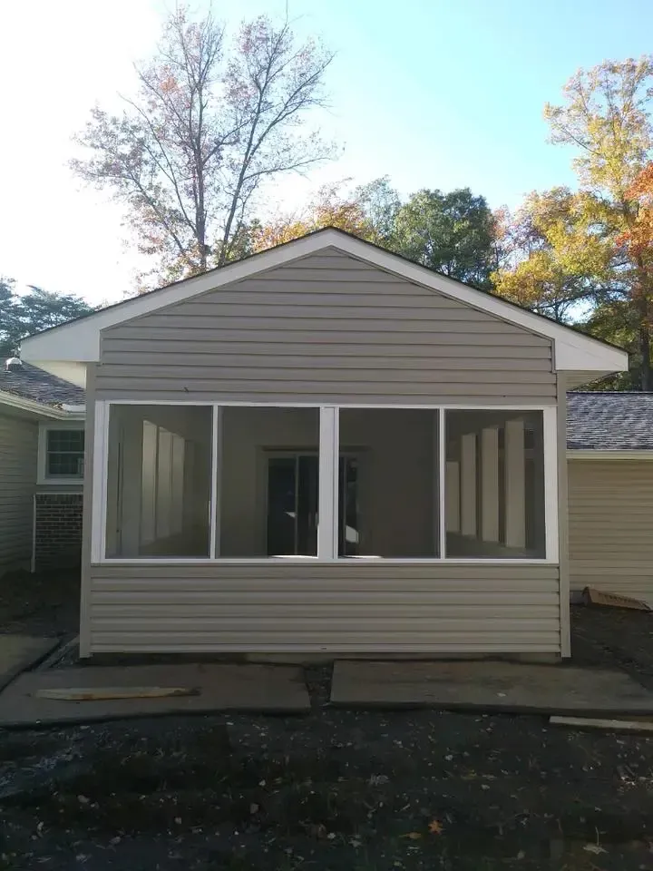 A screened in porch on the side of a house