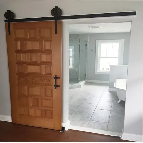 A sliding barn door is open to a bathroom.