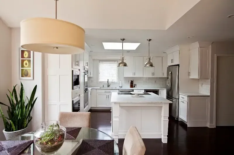 A kitchen with white cabinets and a large island in the middle of the room.