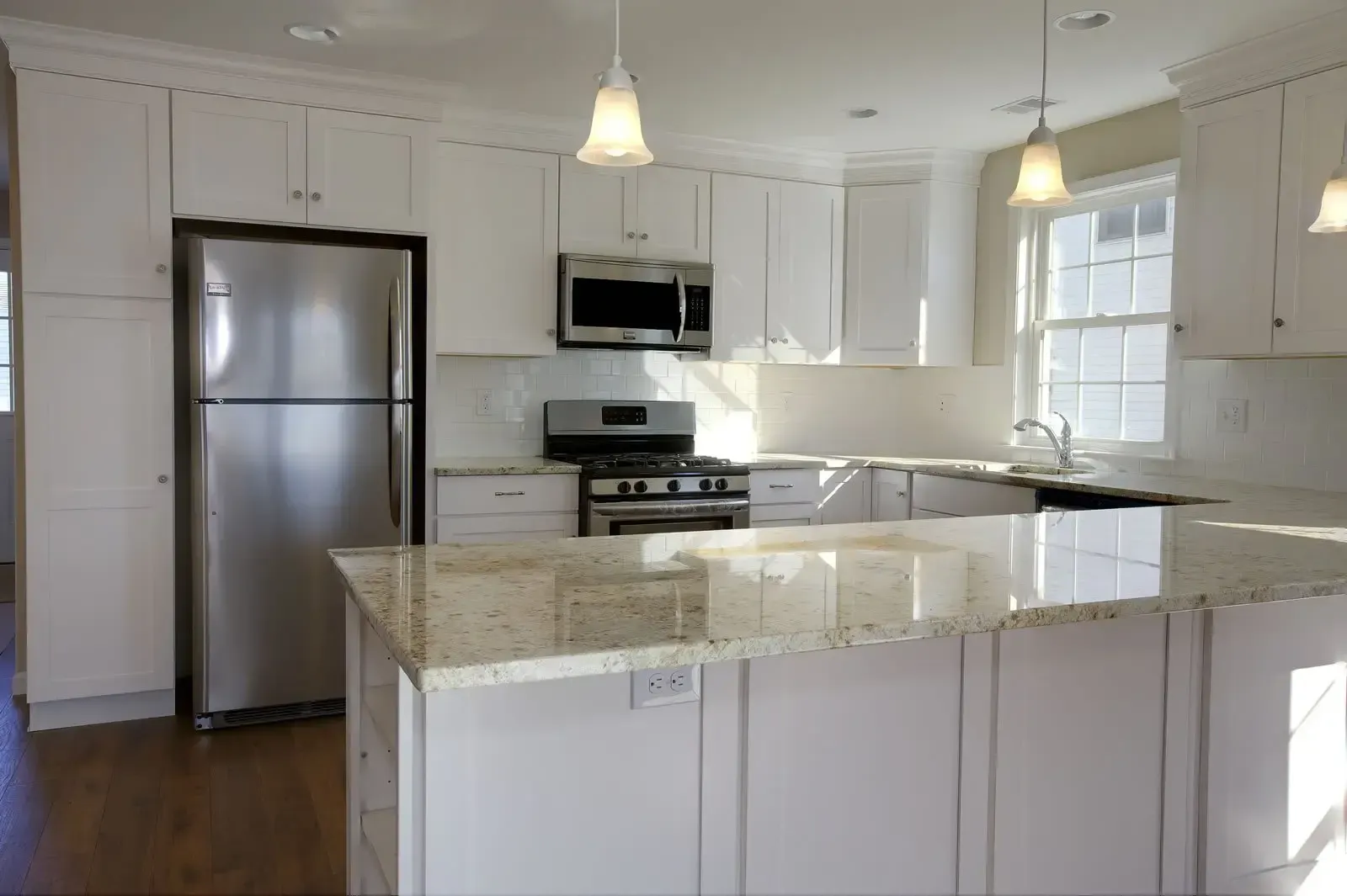 A kitchen with white cabinets stainless steel appliances and granite counter tops