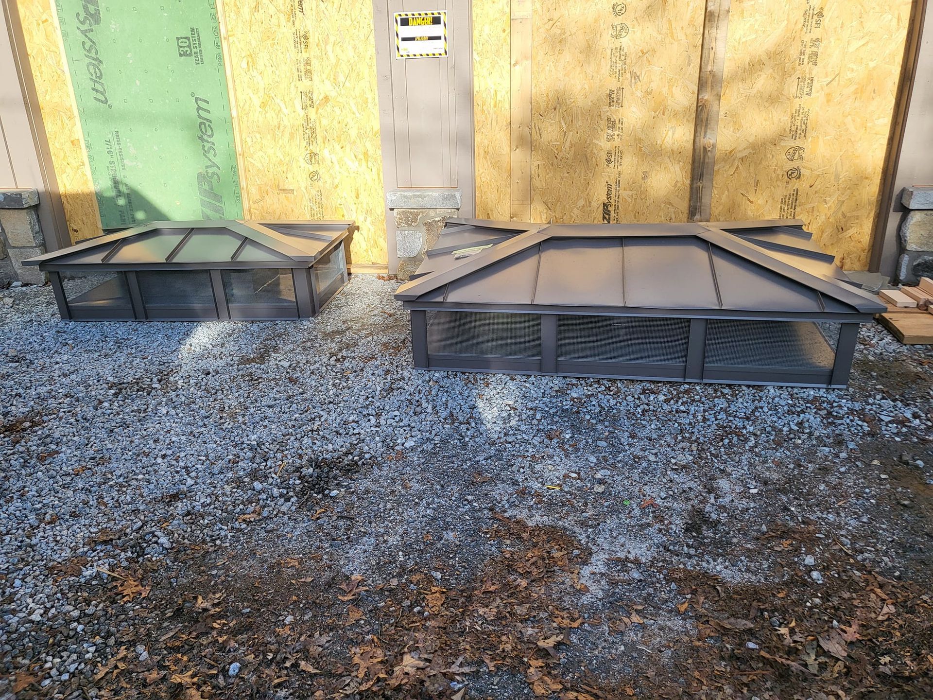 A couple of boxes sitting on top of a pile of gravel in front of a building.