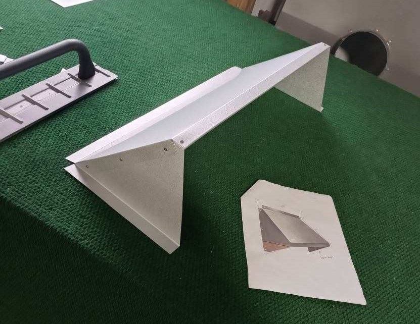 A paper airplane is sitting on top of a green table