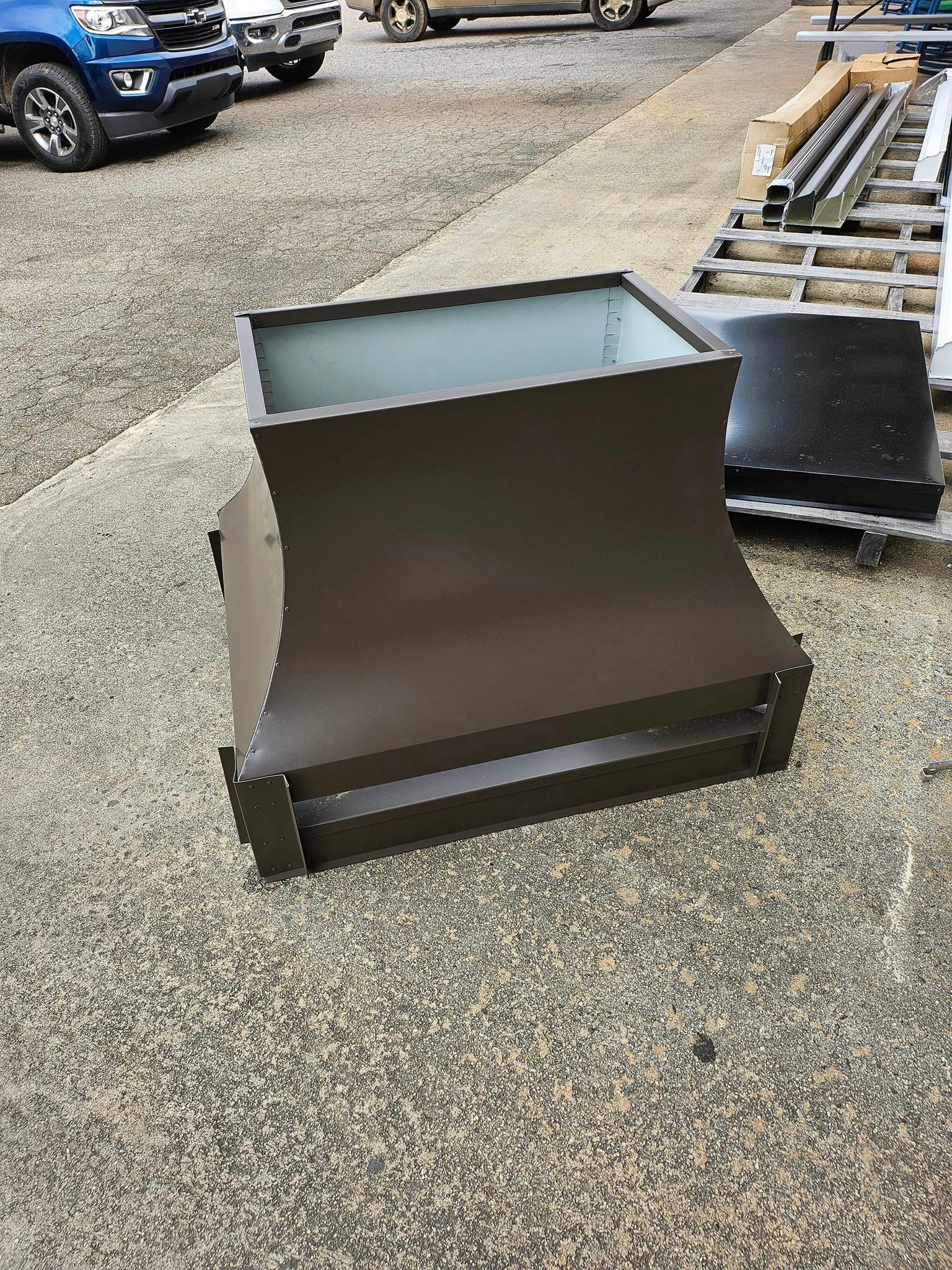 A brown box is sitting on the ground next to a pallet.