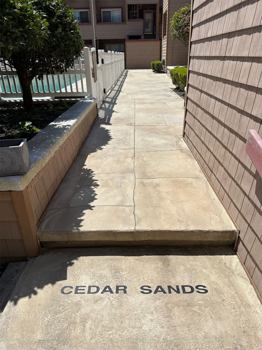 Apartment walkway with steps and “CEDAR SANDS” on the concrete entrance