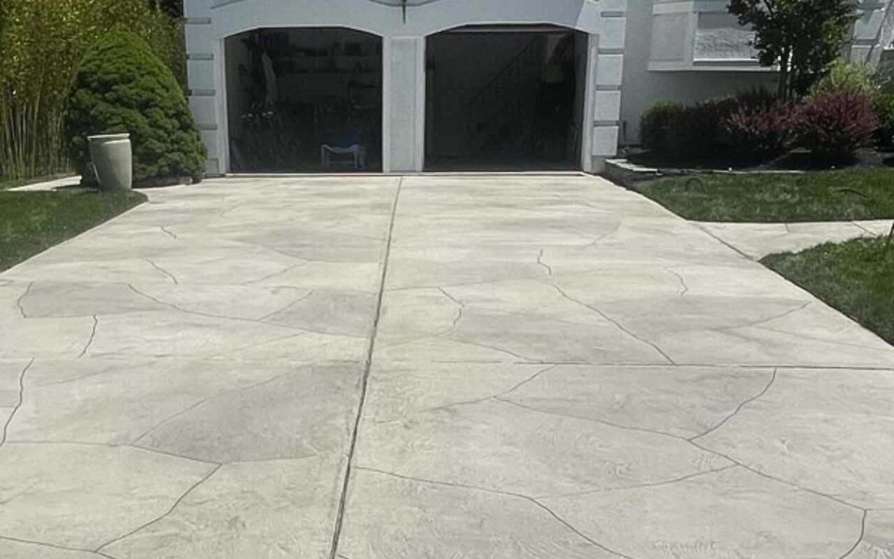 Wide concrete driveway leading to a two-car garage at a suburban house