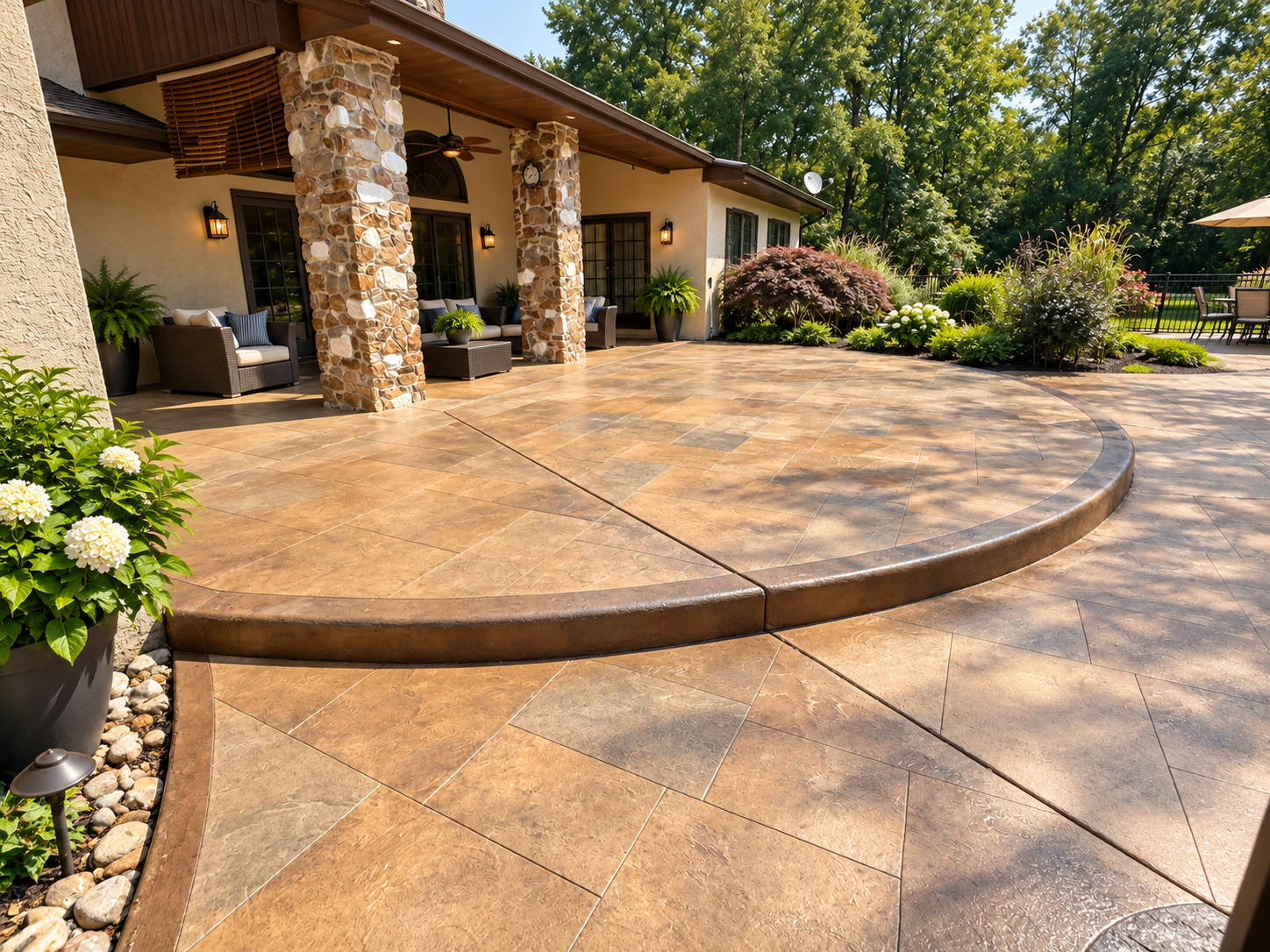 Stone patio with curved steps beside a house and landscaped garden
