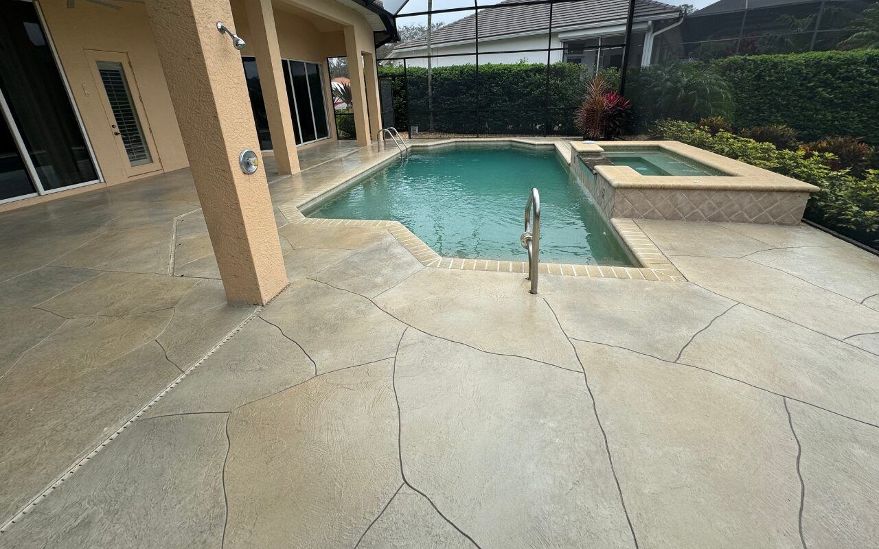 Backyard pool with tan stone patio and covered patio area