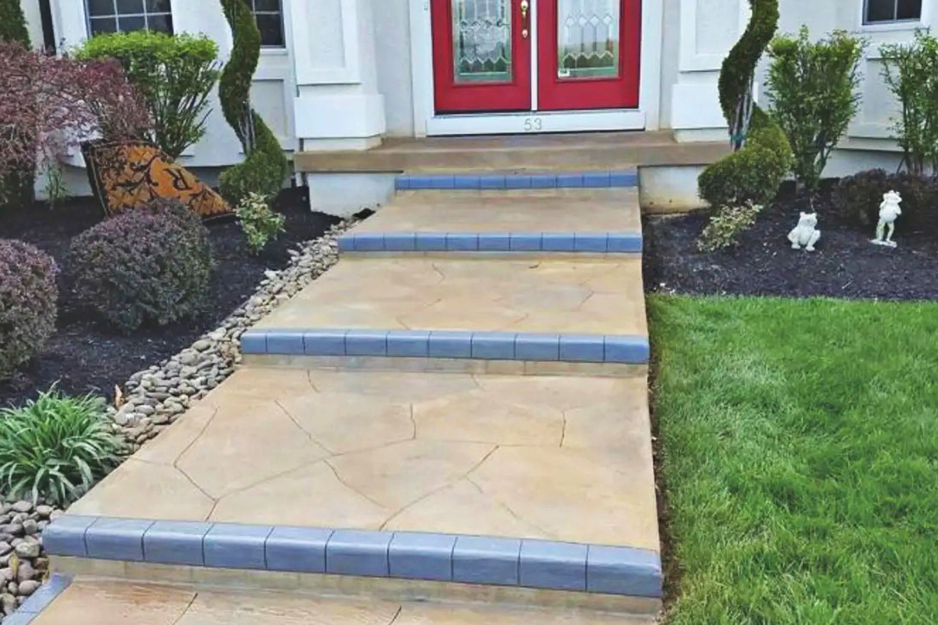 Front walkway with tan steps, blue trim, and red double doors leading to a house