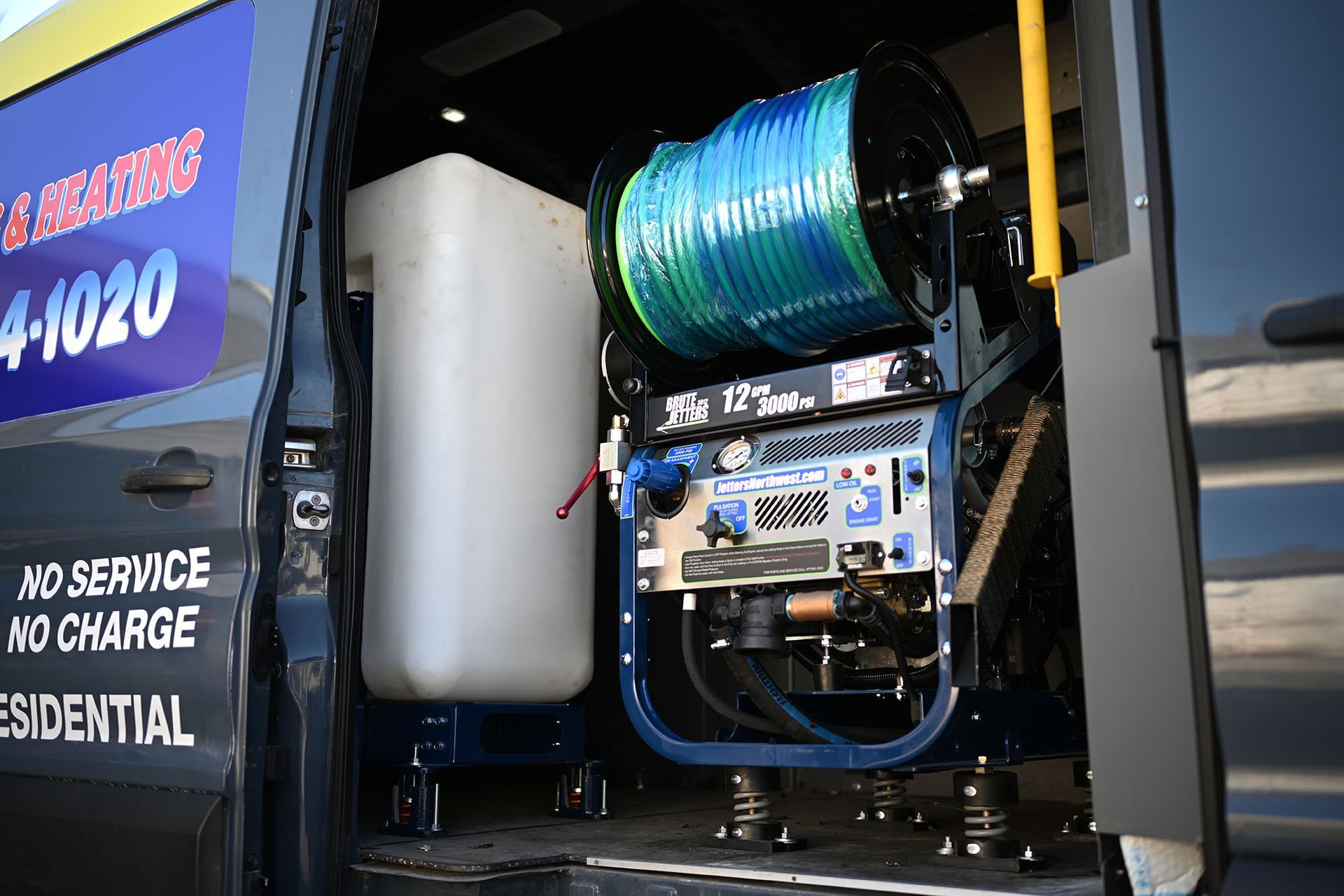 A black van with the door open and a machine in the back.