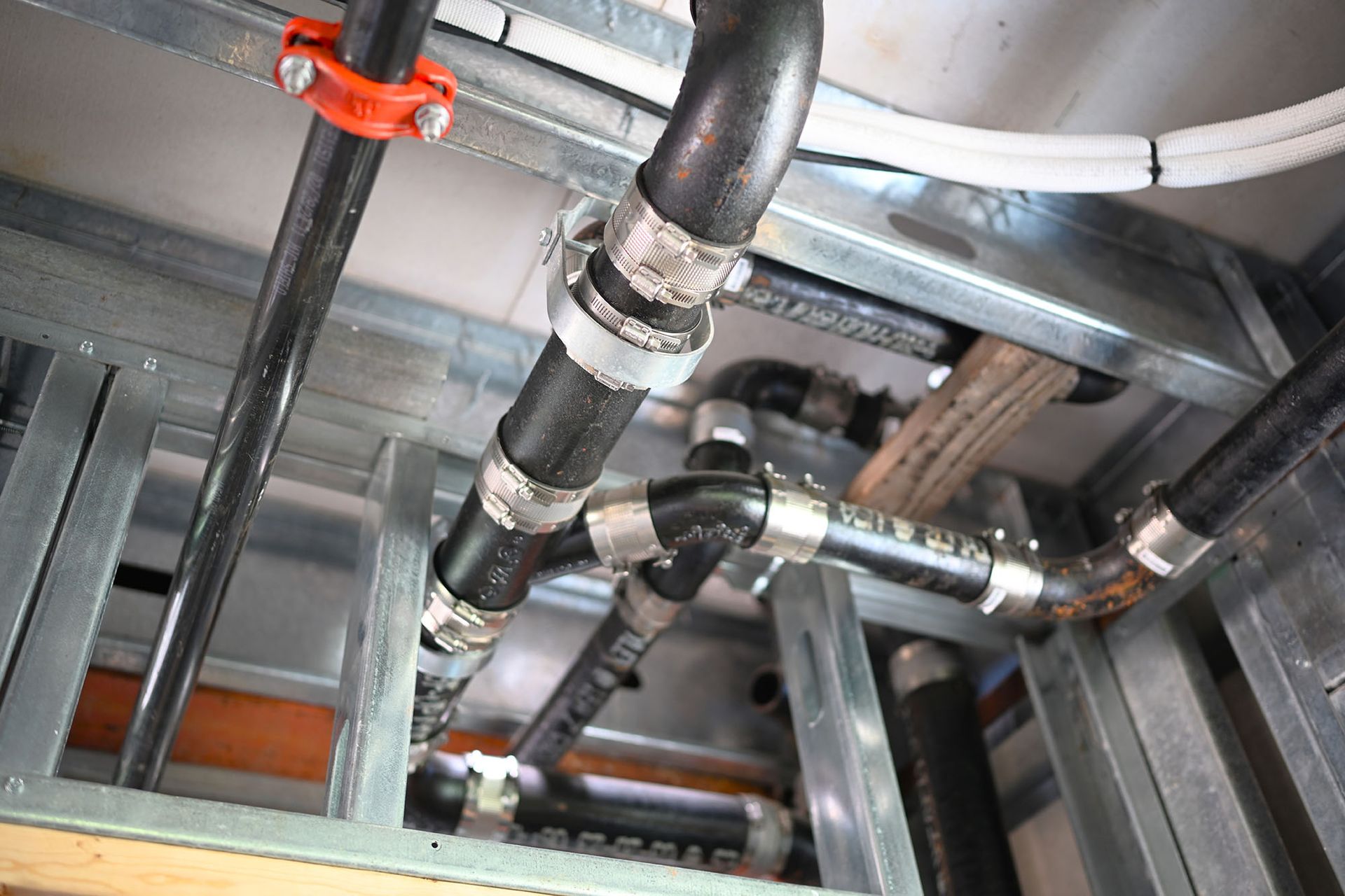 A bunch of pipes are hanging from the ceiling in a room.