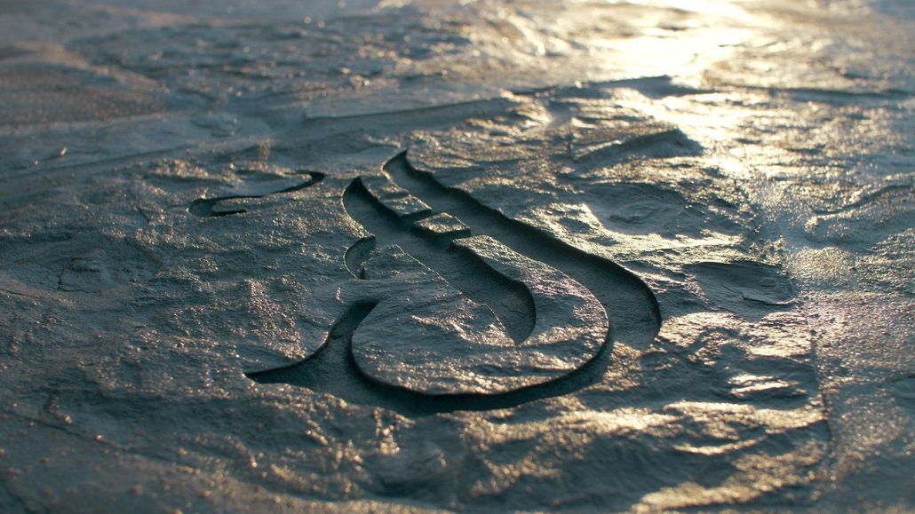 Intricate carving in stone, possibly a letter 