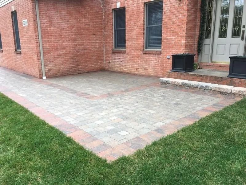 Brick house with paved patio and grass lawn.