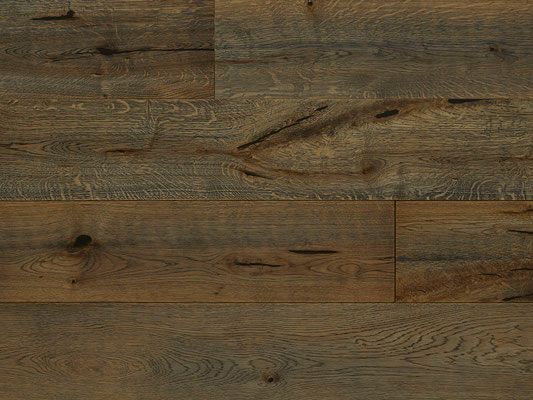 Wood flooring with various shades of brown and gray, showing wood grain and knots.