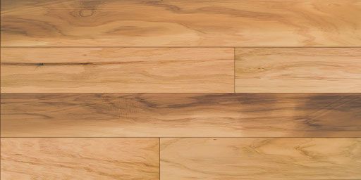 Close-up of wooden floorboards; light brown with varying wood grain patterns.