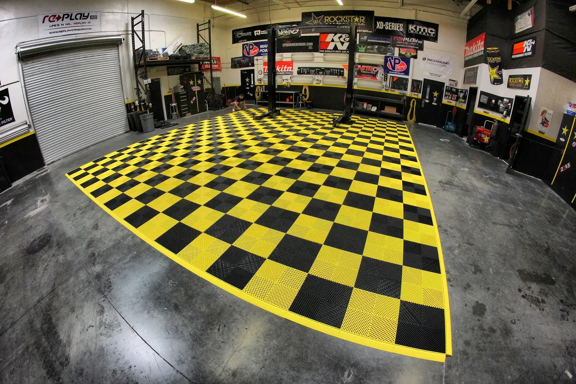 Garage with checkered yellow and black flooring, tools, and equipment.