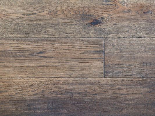 Close-up of weathered wood flooring planks in shades of brown and gray.