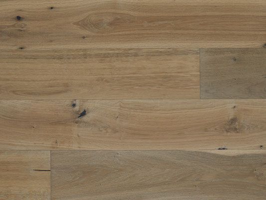 Close-up of light brown hardwood flooring with natural wood grain and knots.