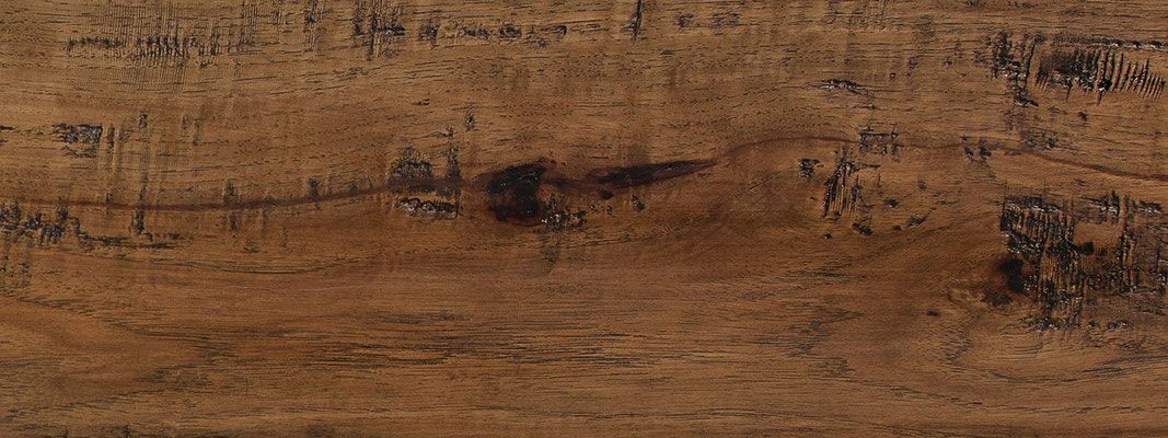 Close-up of a brown wood plank with various dark and light wood grains.
