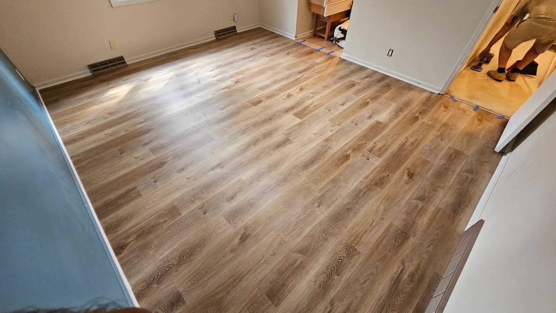 Empty room with wood-look flooring, white walls, and an open doorway