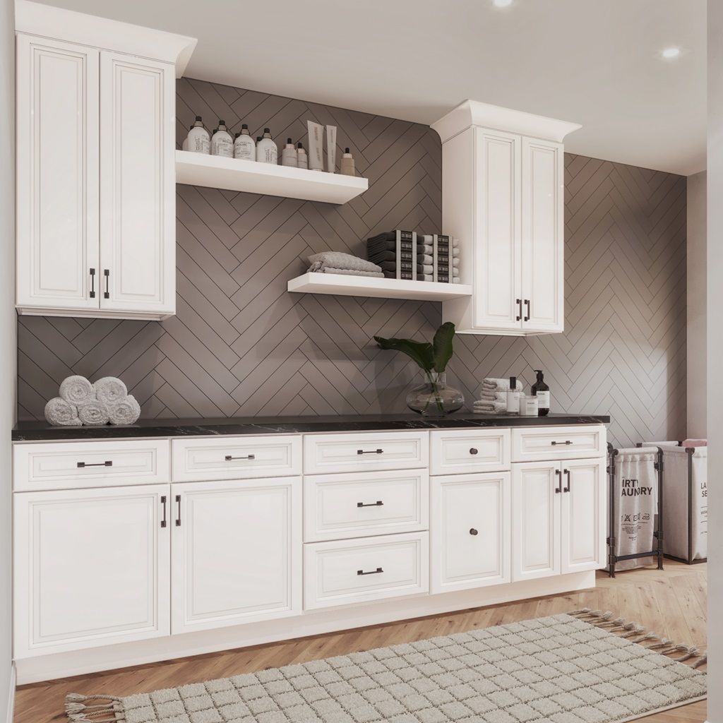 White cabinets with black countertops and gray herringbone backsplash in a laundry room.