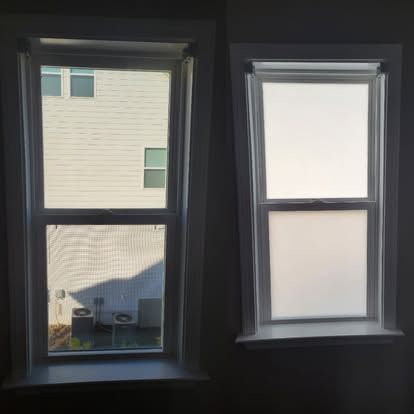 Side-by-side windows: one clear with an outdoor view and one with frosted privacy film obscuring the view.