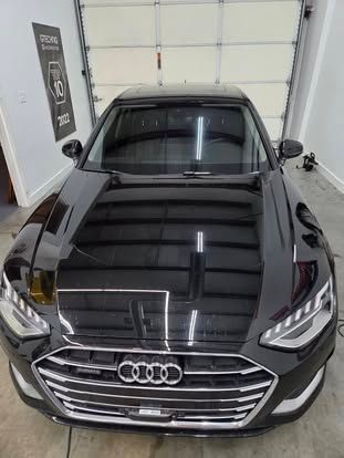 High-angle view of a shiny black Audi parked inside a garage.