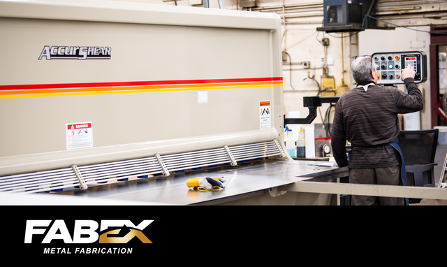 Worker operating industrial machine in factory, with FABEX logo at bottom left