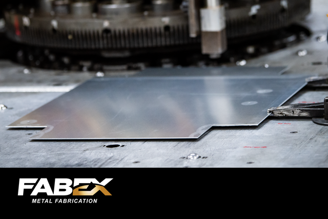 Metal sheet on industrial machine with FABEX logo in the corner