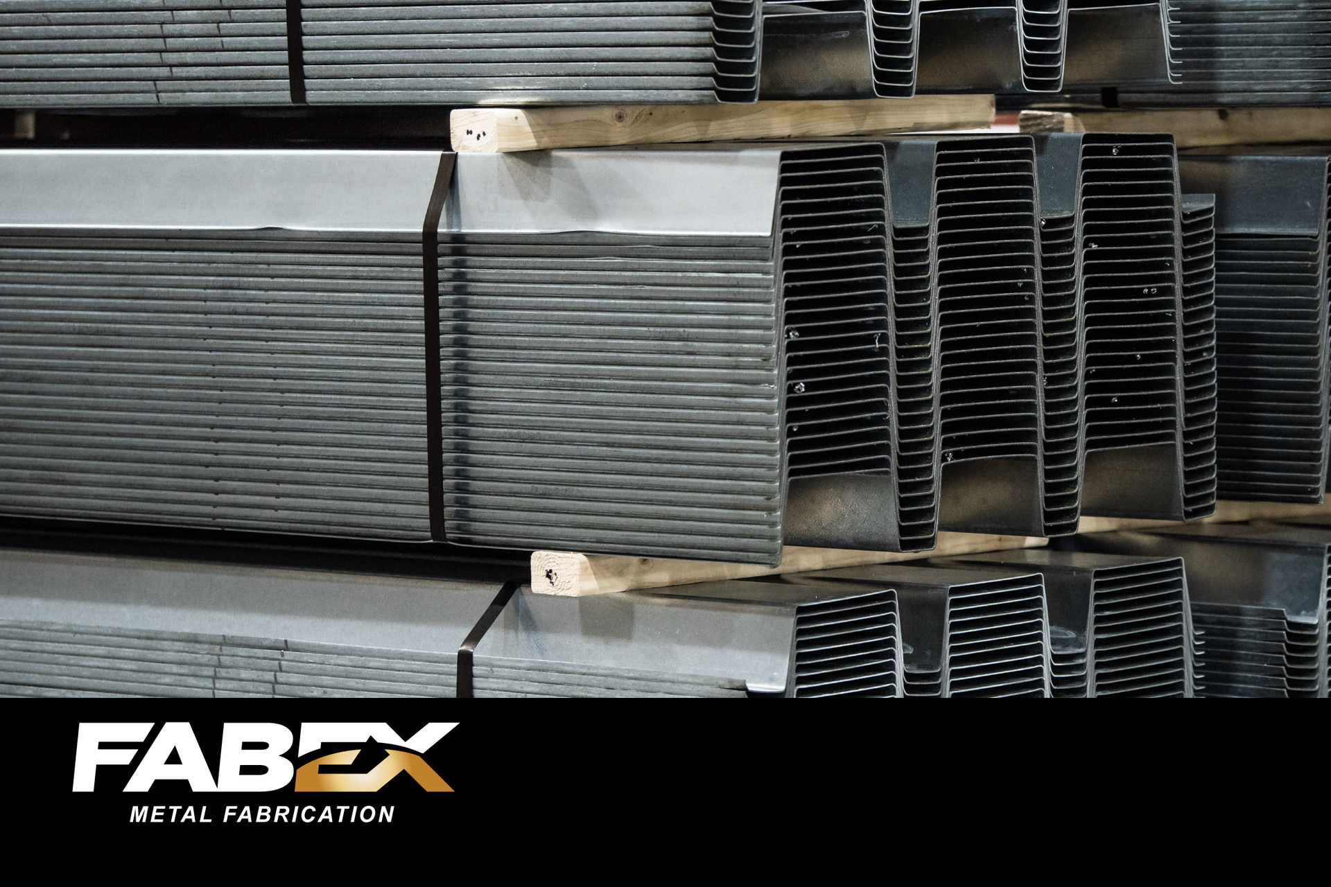 Stacks of metal sheets and channels on racks in a FABEX steel fabrication warehouse