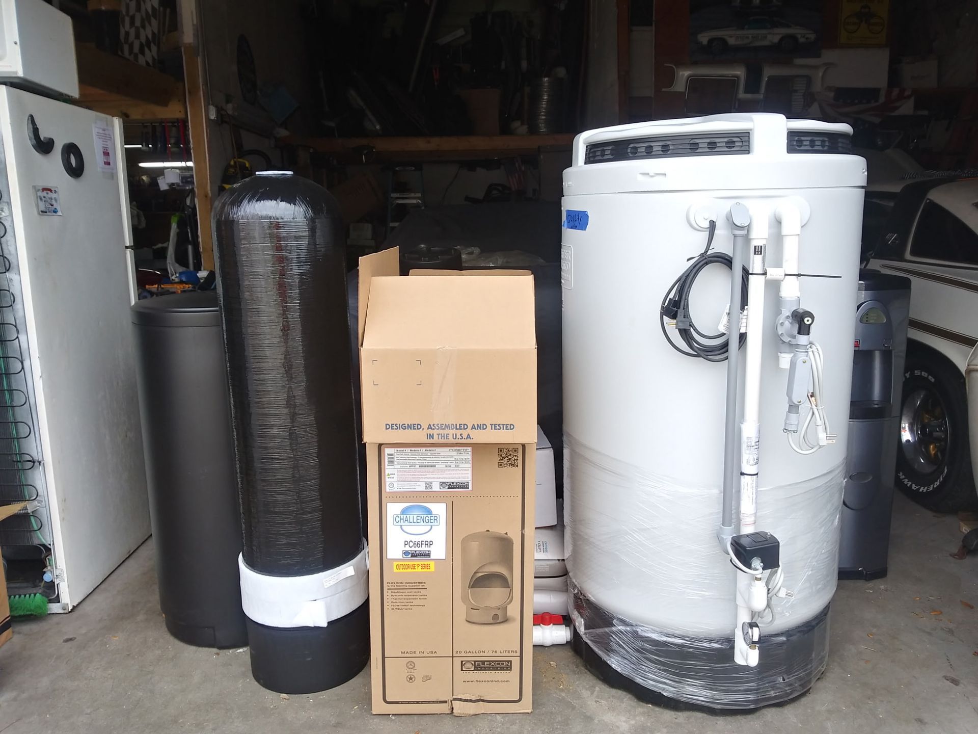 Water softener equipment and cardboard boxes stored in a garage or utility room.