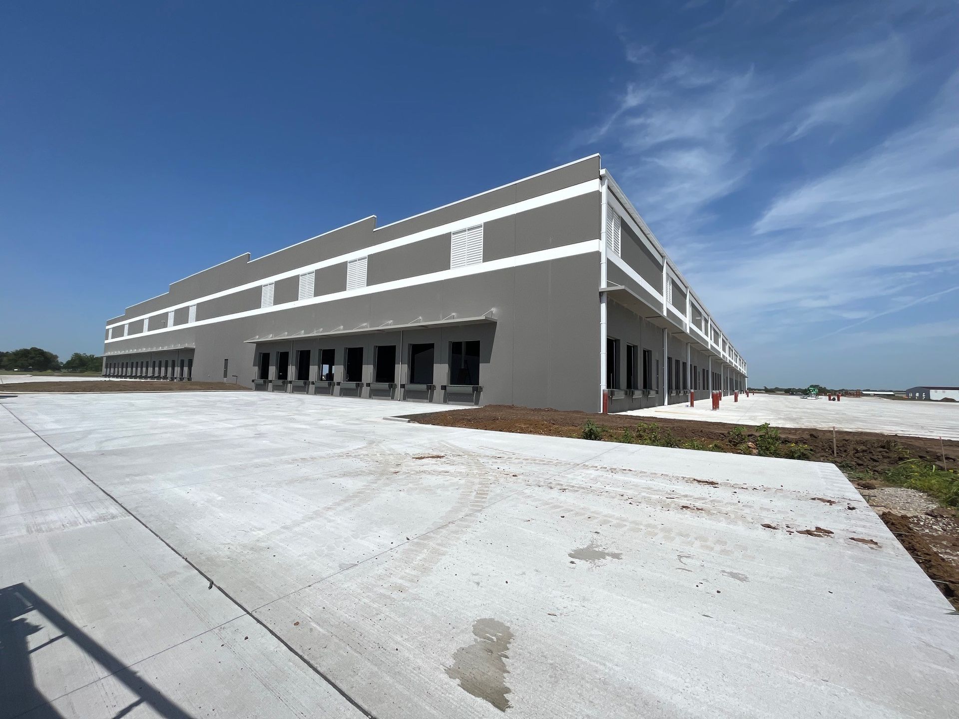 A large building with a lot of doors and a concrete driveway in front of it
