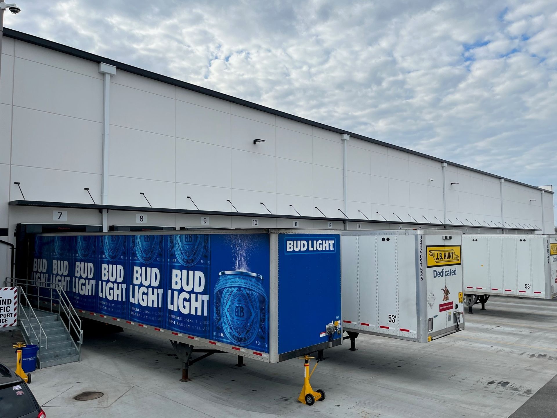 A bud light trailer is parked in front of a building.