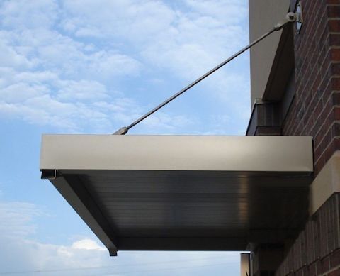 A canopy is attached to the side of a brick building