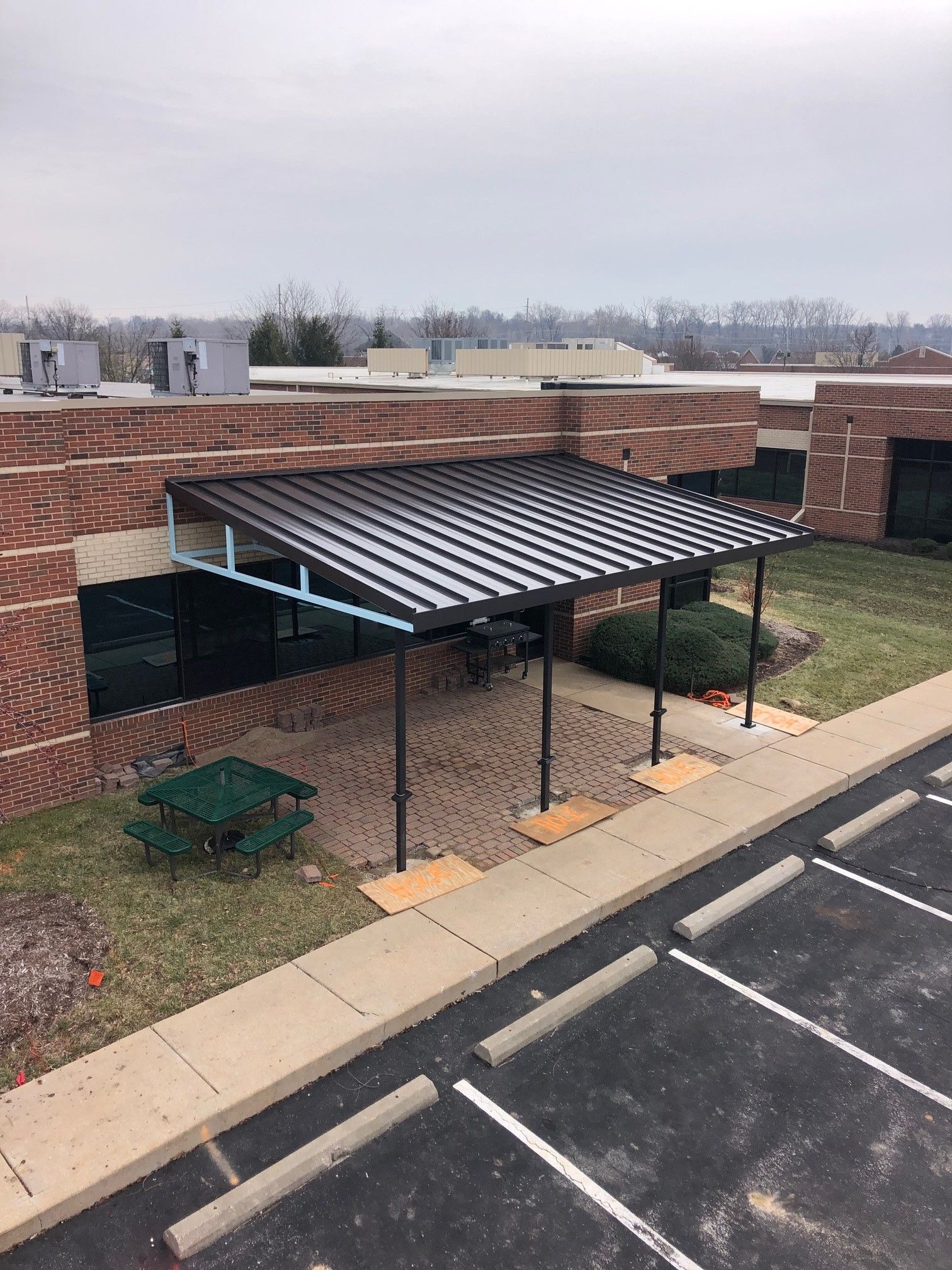 An aerial view of a building with a covered area in front of it.